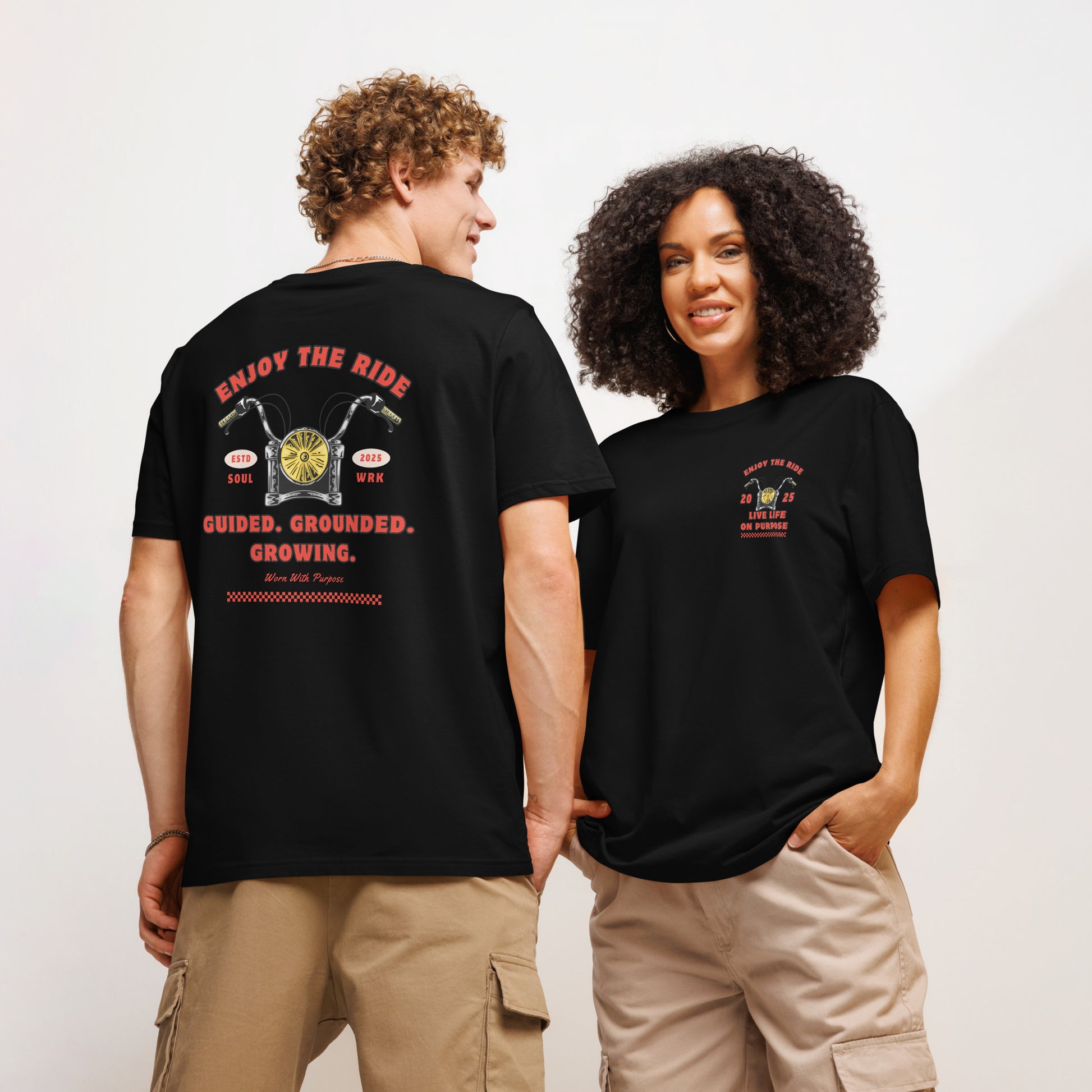 Black T-shirt with red ‘Enjoy The Ride- Guided. Grounded. Growing.’ Motivational text on clean, modern design. 